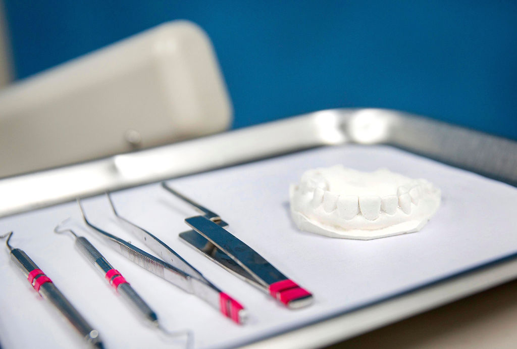 Dental instruments and a white teeth mold on a tray