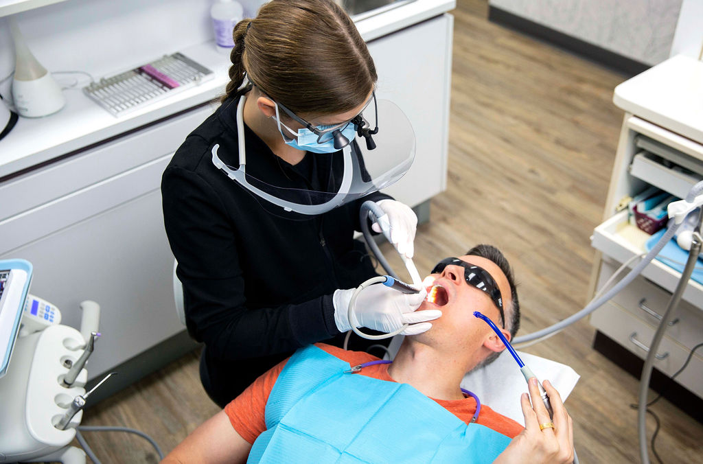 Dental hygienist cleaning a man's teeth